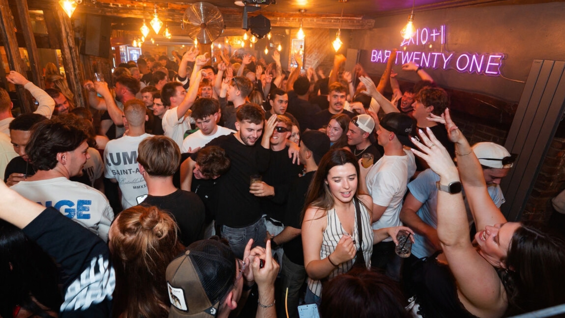Friends dancing and drinking on a packed night at Bar Twenty One